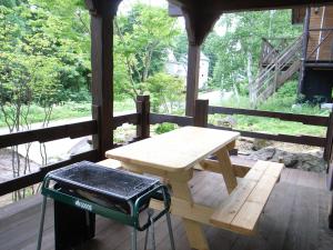 a picnic table on the porch of a house at Cottage All Resort Service / Vacation STAY 8445 in Inawashiro