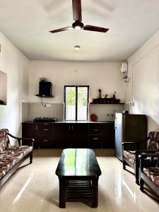 a living room with a ceiling fan and a table at Private Farmhouse Villa Bir 15 Min From Paragliding in Chauntrā