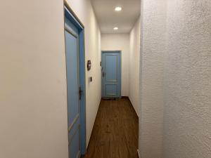 pasillo con puerta azul y suelo de madera en Torque Stays, en Noida