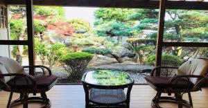 a view of a garden from a window with chairs and a glass table at Kumano - House / Vacation STAY 9764 in Kumano