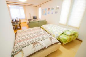a bedroom with two beds and a couch in it at Hello house / Vacation STAY 2248 in Sapporo