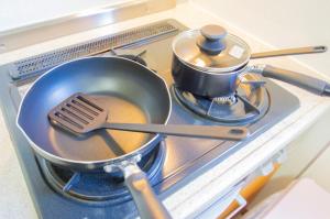 a pan with a spatula and a pot on a stove at Hello house / Vacation STAY 2248 in Sapporo +29 photos