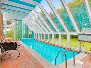 an indoor swimming pool with a glass ceiling and windows at 6 person holiday home in Farsø in Hvalpsund