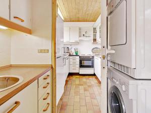 a kitchen with white cabinets and a washer and dryer at 6 person holiday home in Farsø in Hvalpsund