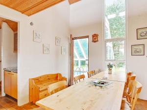 a kitchen and dining room with a wooden table at 6 person holiday home in Farsø in Hvalpsund +33 photos