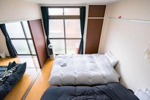 une chambre avec un lit et une grande fenêtre dans l'établissement Murata Corpo / Vacation STAY 4497, à Tokyo