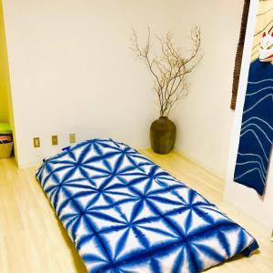a blue pillow on the floor in a room with a vase at Room 202 / Vacation STAY 13909 in Tokushima