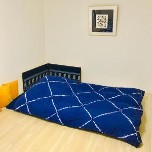 a blue comforter on a bed in a room at Room 202 / Vacation STAY 13909 in Tokushima +14 photos