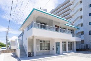 a white house with a blue roof at 栞-shiori-FUNAKURA in Ishigaki Island