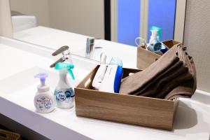 ein Waschbecken im Bad mit einer Holzkiste und Pflegeprodukten in der Unterkunft Rakuten STAY HOUSE x WILL STYLE Sasebo 103 in Sasebo + 49 Fotos