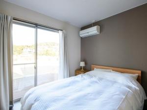 ein Schlafzimmer mit einem Bett und einem großen Fenster in der Unterkunft Rakuten STAY HOUSE x WILL STYLE Sasebo 104 in Sasebo