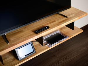 TV de pantalla plana sobre una mesa de madera en Rakuten STAY HOUSE x WILL STYLE Sasebo 106, en Sasebo
