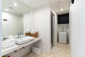 a white bathroom with a sink and a mirror at Lala court seaside Yagaji / Vacation STAY 3226 in Nago +30 photos