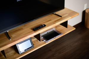 a flat screen tv sitting on top of a wooden entertainment center at Rakuten STAY HOUSE x WILL STYLE Sasebo 101 in Sasebo