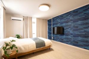 a bedroom with a blue brick accent wall at 栞-shiori-FUNAKURA in Ishigaki Island