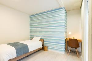a bedroom with a blue and white striped wall at 栞-shiori-FUNAKURA in Ishigaki Island