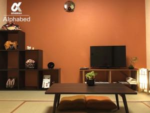 ein Wohnzimmer mit Tisch und Fernseher in der Unterkunft Alphabed Takamatsu Kitahama EAST 203 / Vacation STAY 20107 in Takamatsu