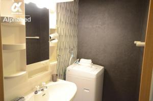 ein Badezimmer mit Waschbecken, Toilette und Spiegel in der Unterkunft Alphabed Takamatsu Kitahama EAST 203 / Vacation STAY 20107 in Takamatsu