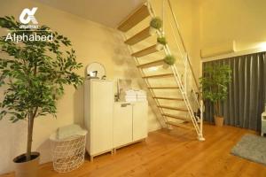 eine Treppe in einem Raum mit Topfpflanzen in der Unterkunft Alphabed TakamatsuKawaramachi EAST 602 / Vacation STAY 20477 in Takamatsu