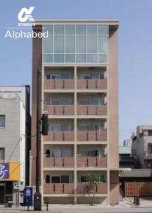 ein hohes Gebäude mit Fenstern in einer Stadt in der Unterkunft Alphabed TakamatsuKawaramachi EAST 602 / Vacation STAY 20477 in Takamatsu