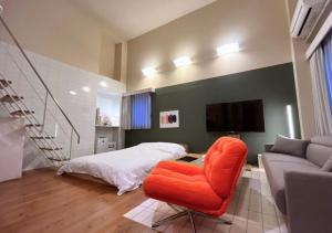 - une chambre avec une chaise orange et un lit dans l'établissement Alphabed TakamatsuKawaramachi WEST 702 / Vacation STAY 21599, à Takamatsu 6 autres photos