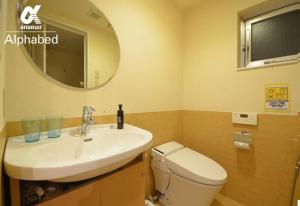 une salle de bain avec un lavabo, des toilettes et un miroir dans l'établissement Alphabed TakamatsuKawaramachi WEST 702 / Vacation STAY 21599, à Takamatsu