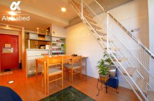 ein Esszimmer mit einem Tisch und einer Treppe in der Unterkunft Alphabed TakamatsuKawaramachi 501 / Vacation STAY 21604 in Takamatsu