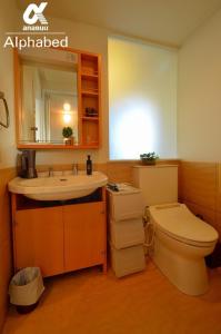 ein Badezimmer mit Waschbecken, Toilette und Spiegel in der Unterkunft Alphabed TakamatsuKawaramachi 501 / Vacation STAY 21604 in Takamatsu + 9 Fotos