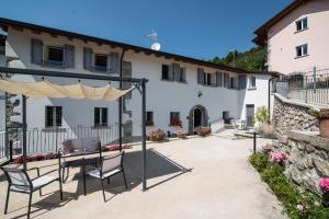 圣佩莱格里诺温泉Villa Mariolino的建筑物前有桌椅的露台