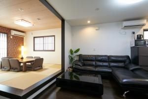 ein Wohnzimmer mit einer Ledercouch und einem Tisch in der Unterkunft Kyoto - House - Vacation STAY 41844v in Kyoto