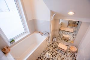 a bathroom with a tub and a tiled floor at RUSUTSU HOLIDAY CHALET / Vacation STAY 3822 in Makkari +31 photos