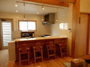 a kitchen with a bar with chairs around it at Uruma - House - Vacation STAY 16594 in Uruma