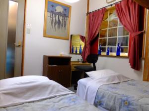a room with two beds and a desk and a window at Kameda-gun - Cottage / Vacation STAY 34923 in Nanae