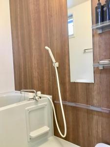 a bathroom with a white urinal on a wooden wall at A-style Futenma / Vacation STAY 35875 in Ginowan +17 photos