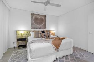 Un pat sau paturi într-o cameră la 329 Contemporary Apartment in Beachfront Resort Palm Cove +29 fotografii