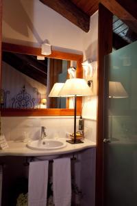a bathroom with a sink with a lamp and towels at Hotel Antsotegi in Etxebarria