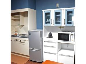 a kitchen with a refrigerator and a microwave at Yokocho Building / Vacation STAY 42628 in Beppu