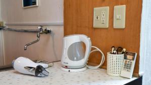 a kitchen appliance on a counter next to a telephone at Siｍple Stay Makishi / Vacation STAY 43354 in Naha
