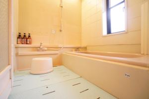 a bathroom with a tub and a toilet and a sink at Takayama - House / Vacation STAY 44324 in Takayama +8 photos
