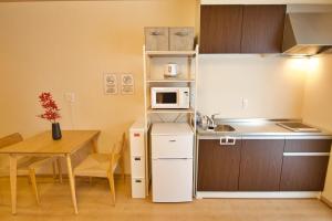 Una pequeña cocina con una mesa y un microondas. en Kamon Inn Uji 2-C, en Uji 17 fotos más