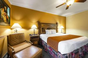 a hotel room with two beds and a lamp at La Hacienda Inn in San Antonio