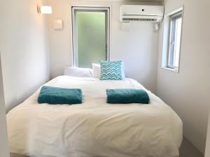 a bed with two green pillows on top of it at Nakagami-gun - House / Vacation STAY 45165 in Yomitan