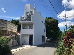 a white building with a staircase on the side of it at Nakagami-gun - House / Vacation STAY 45165 in Yomitan
