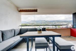 a table and chairs in a room with a couch at La Tonnelle - 42m2 - Terrasse - Sainte-Clotilde in Saint-Denis
