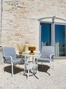 dos sillas y una mesa y una mesa y sillas en Casale Del Musico, en Locorotondo