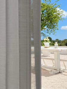 a white table with a white vase on it at Casale Del Musico in Locorotondo