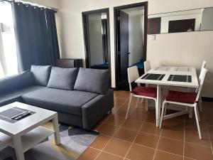 a living room with a couch and a table at 2BR Condo in Makati- Good for 6! in Manila
