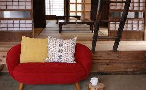a red chair with a yellow pillow in a room at Uenohara - House / Vacation STAY 47885 in Uenohara +2 photos