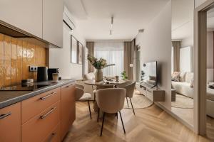 a kitchen and living room with a table and chairs at Electra Apartments in Krakow