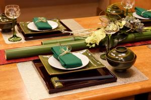 a table with green and white plates and wine glasses at Nagoya - House / Vacation STAY 47242 in Nagoya